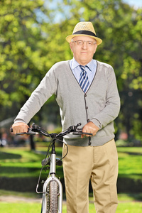老人在公园里推一辆自行车图片