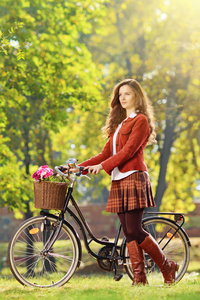 年轻女性在接受自行车放松在公园里