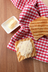 木制的桌子上的奶油烤的面包