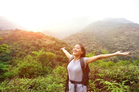 女人欣赏美丽的景色，在山的顶峰