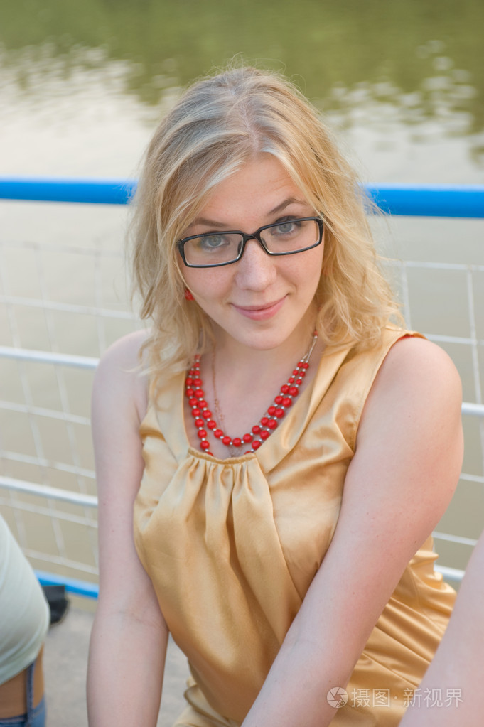 女孩金发女郎坐在甲板上河船的快乐感到惊讶