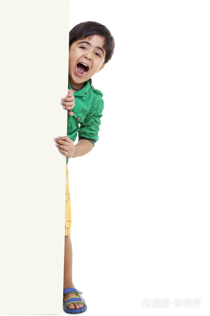 顽皮的小男孩站在空白板