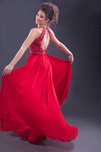迷人的优雅女人，穿着时髦的红色连衣裙
