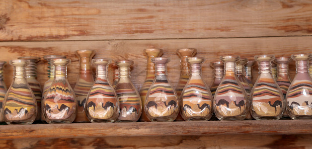 传统的当地纪念品在约旦瓶用沙子和形状的沙漠和骆驼