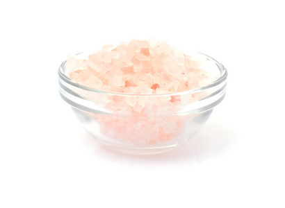 在玻璃碗里孤立的白色背景上的粉红盐