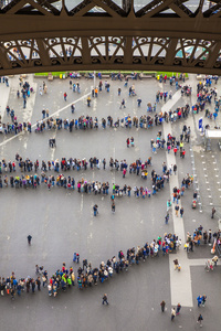 巴黎，法国，2013 年 5 月 2 日。游客站成一行在埃菲尔铁塔