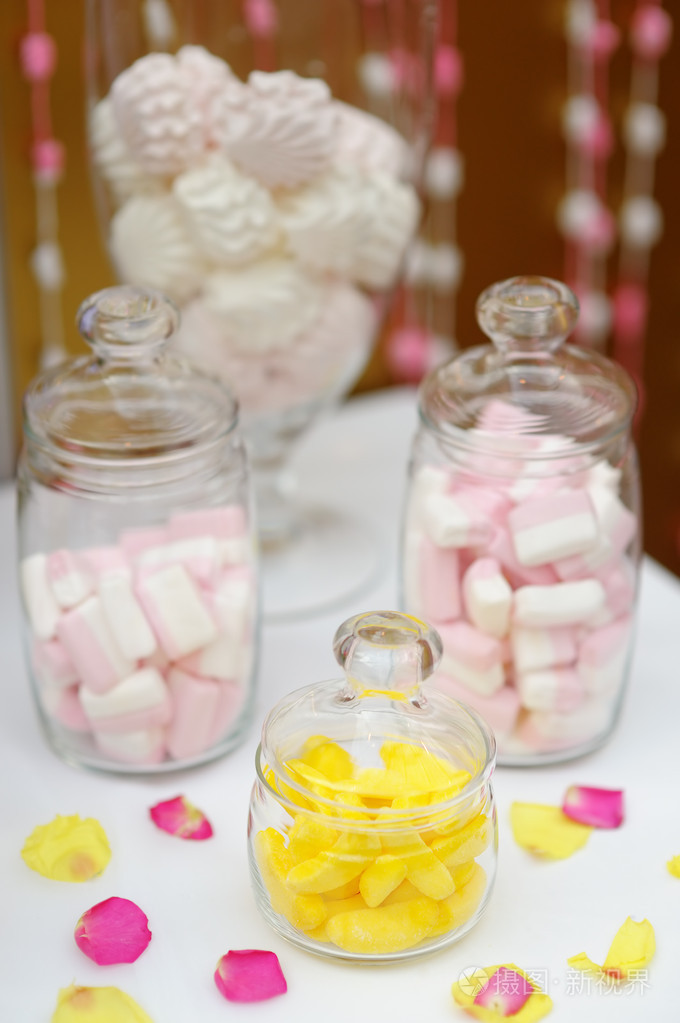 黄色水果,糖果和棉花糖在玻璃罐里