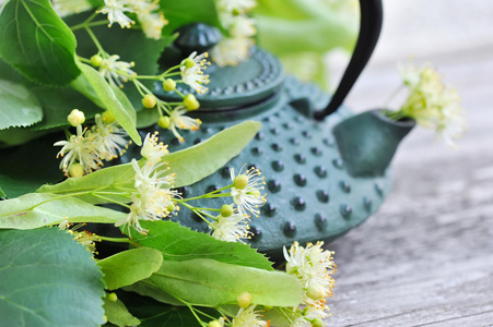 林登茶和老木背景上的花茶壶