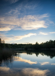 在平静的湖面水域反映了充满活力的夏天日落景色