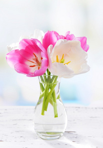美丽的郁金香，在明亮的背景上桌上的花瓶中的存储桶中