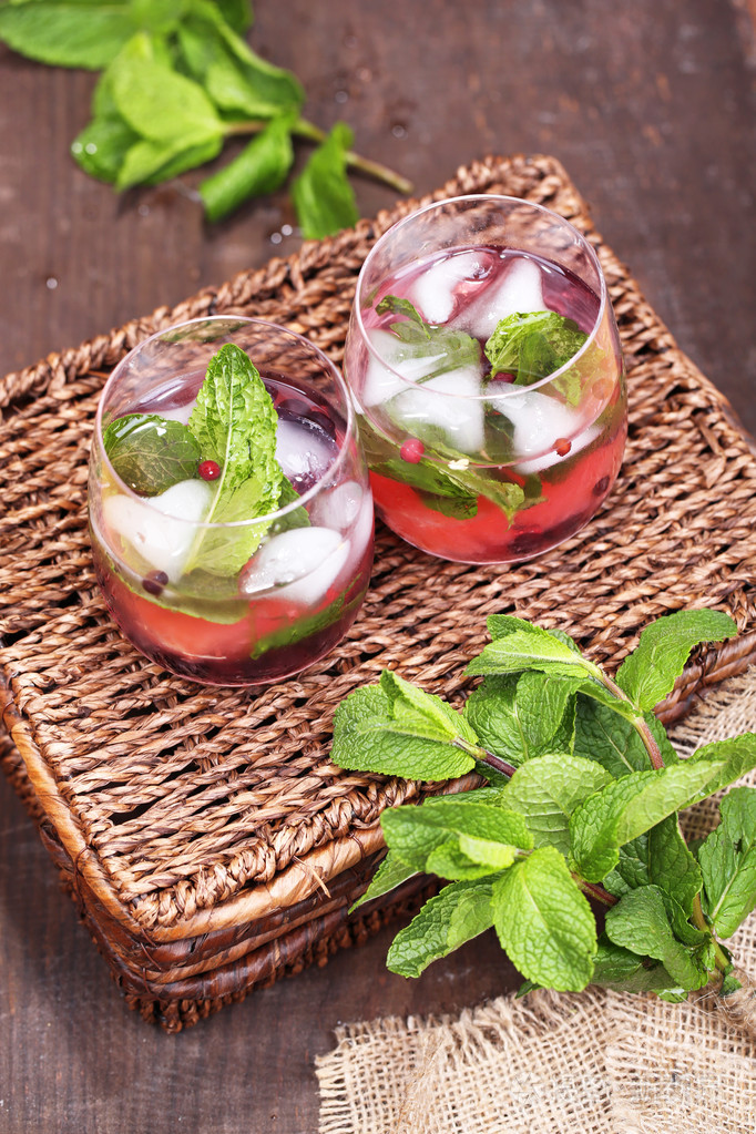 美味的鸡尾酒,用新鲜的葡萄柚和薄荷叶在木桌背景上