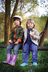 两个男孩在森林的长椅上吃包子