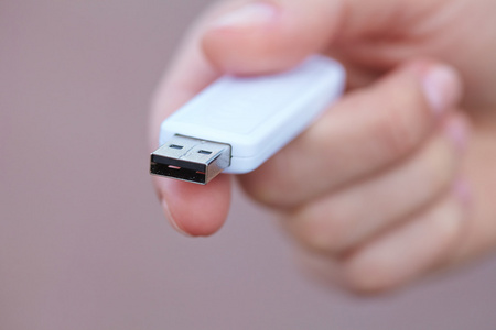 手中拿着黑色的 usb 数据存储