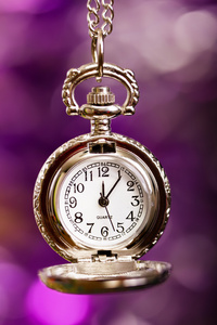节日的紫色背景上的银色复古时钟