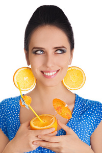 橙汁饮料与橙片耳环白色背景的女孩