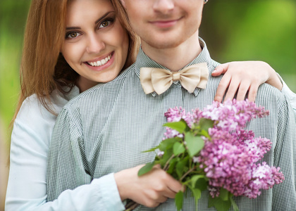 paar in Liebe im Park Lcheln halten einen Strau lila Blume