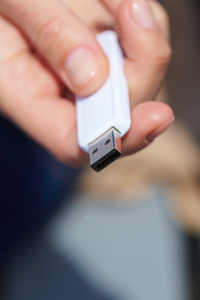 手中拿着黑色的 usb 数据存储