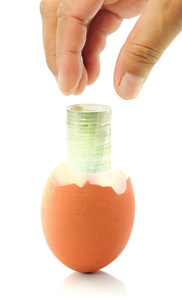 碎钱手放碎蛋壳的硬币照片