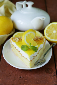 一块柠檬蛋糕塔装饰着新鲜柠檬和薄荷