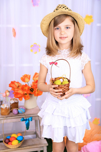 美丽的小女孩抱着用五光十色的篮子鸡蛋装饰背景