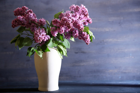 美丽的淡紫色花在花瓶里，颜色木制背景上