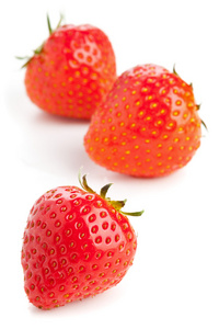 在白色背景的三个草莓