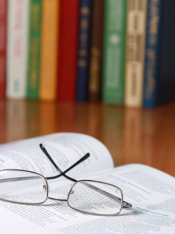 戴着眼镜在桌子上的书