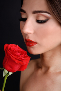 女孩，红红的嘴唇和深色背景上的玫瑰