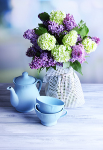 美丽的春天鲜花插在花瓶里，木制的桌子，在明亮的背景上