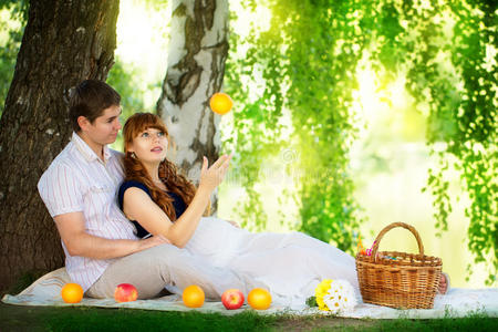 幸福年轻的怀孕夫妇拥抱在大自然中享受夏日公园，户外，新的生活理念。