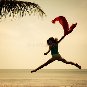 快乐的女孩在海滩上跳跃