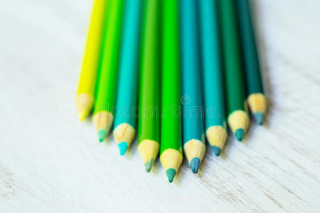 蓝色和绿色铅笔排列在白色上