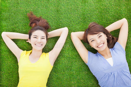 两个快乐的年轻女人在草地上休息