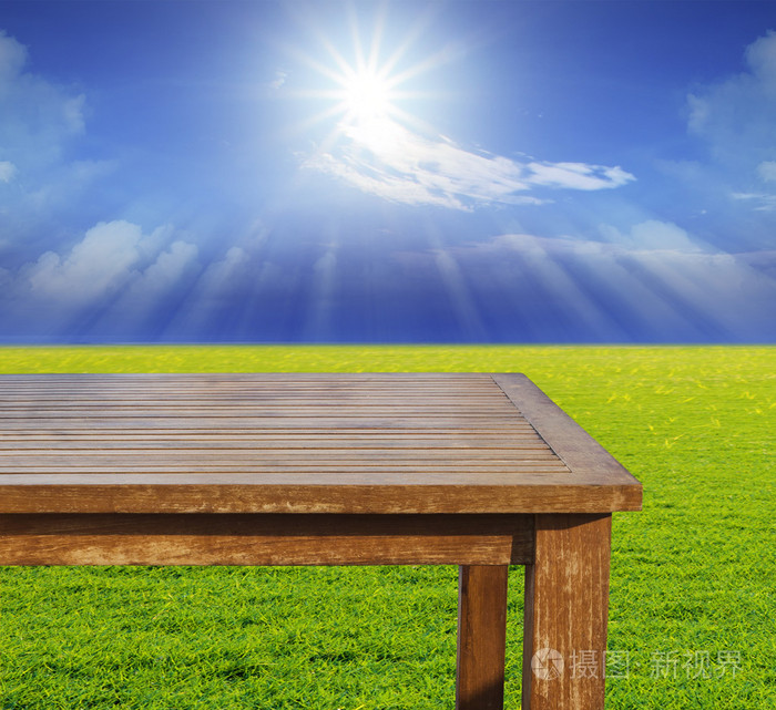 免费空顶木桌子上绿草对阵太阳