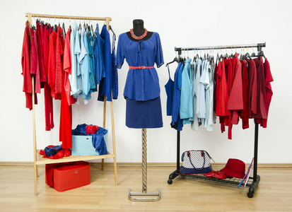 安排在衣架和服装模特儿身上的红色和蓝色衣服的衣柜