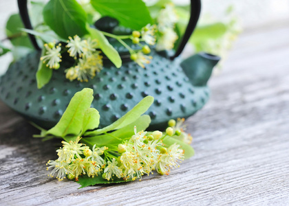 林登茶和老木背景上的花茶壶