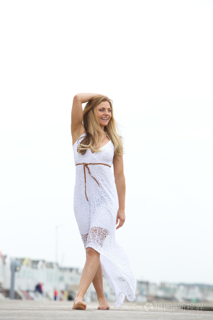 幸福的年轻女人在户外赤脚行走