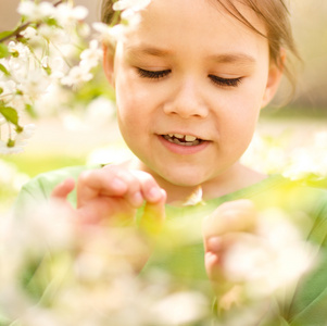 一个小女孩附近树上盛开的肖像