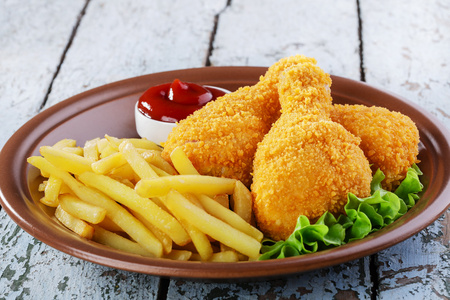面包屑的鸡腿鸡腿炸薯条照片