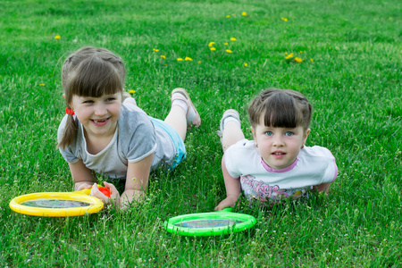 两个小女孩在用拍子草地上