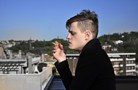 有思想的人在建筑物屋顶上抽烟照片