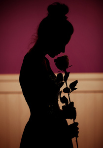 女人拿着一朵玫瑰的影子