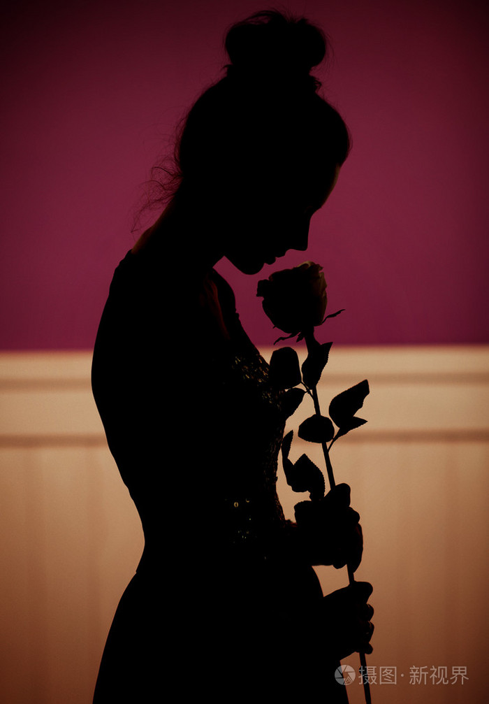 女人拿着一朵玫瑰的影子
