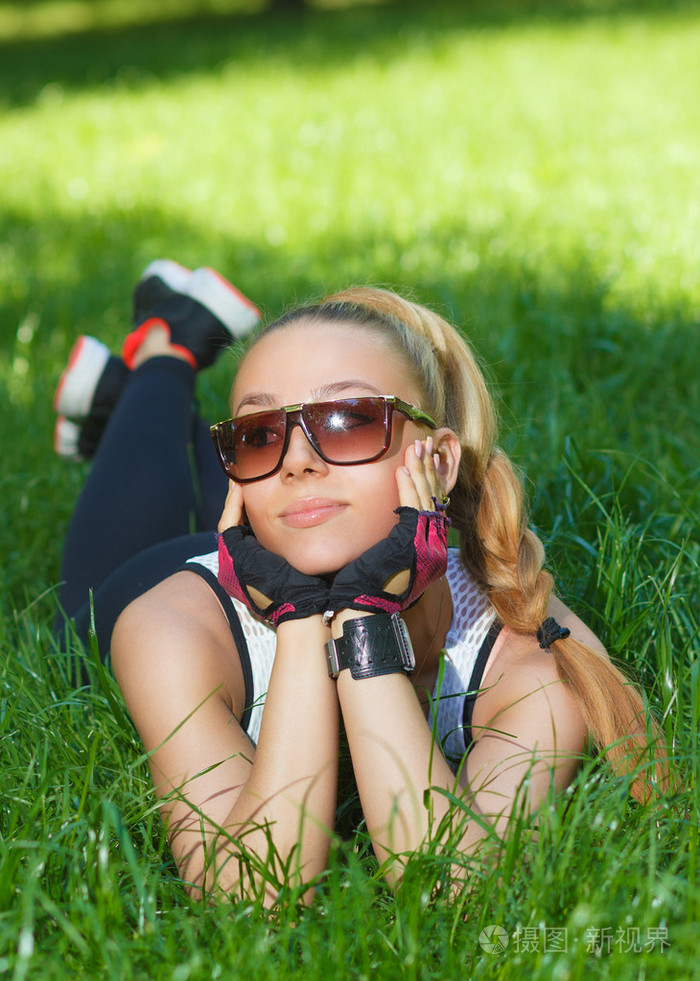 美丽的女运动微笑躺在草地上照片-正版商用图片1ftvoj-摄图新视界