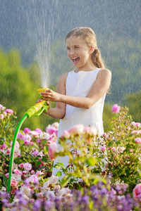 夏天花园 浇水漂亮女孩在浇玫瑰花