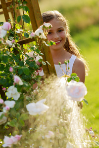 夏天花园 浇水漂亮女孩在浇玫瑰花