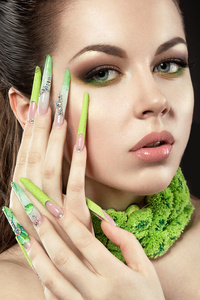 美丽的女孩，长长的绿色指甲与亮妆