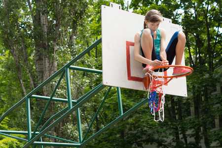 敏捷的年轻女孩，在一个篮球目标固定网