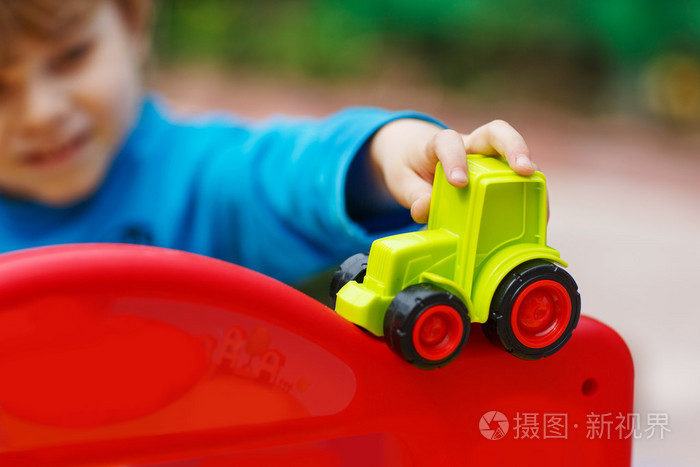 蹒跚学步的小男孩玩玩具车