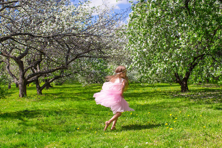 可爱的小女孩，用蝴蝶的翅膀在朵朵苹果园玩得开心